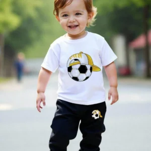 Toddler boy wearing a white short-sleeve soccer t-shirt and black jogger pants summer tracksuit set.