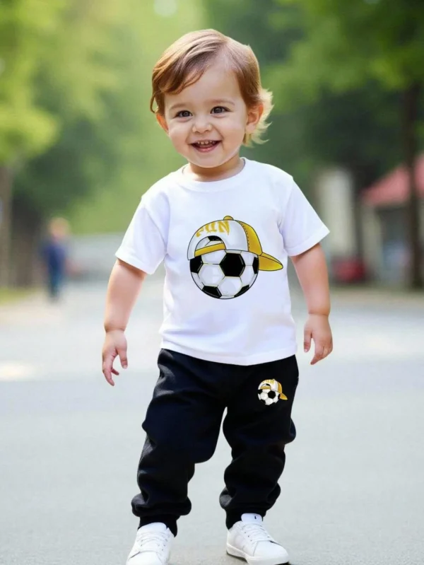 Toddler boy wearing a white short-sleeve soccer t-shirt and black jogger pants summer tracksuit set.