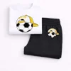Toddler boy wearing a white short-sleeve soccer t-shirt and black jogger pants summer tracksuit set.