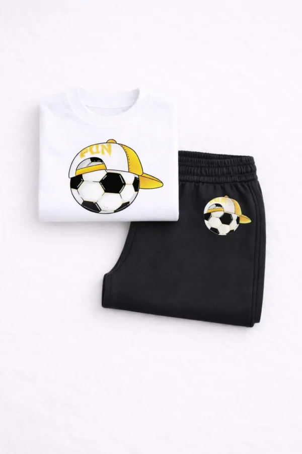 Toddler boy wearing a white short-sleeve soccer t-shirt and black jogger pants summer tracksuit set.